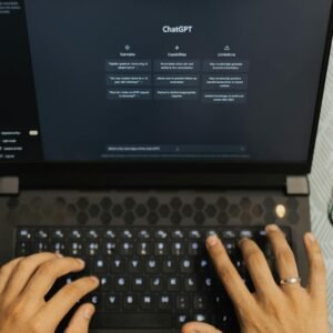 Hands typing on a laptop with ChatGPT open, wireless technology theme.