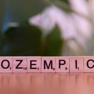 Scrabble tiles spelling 'Ozempic' on a wooden surface, healthcare theme.